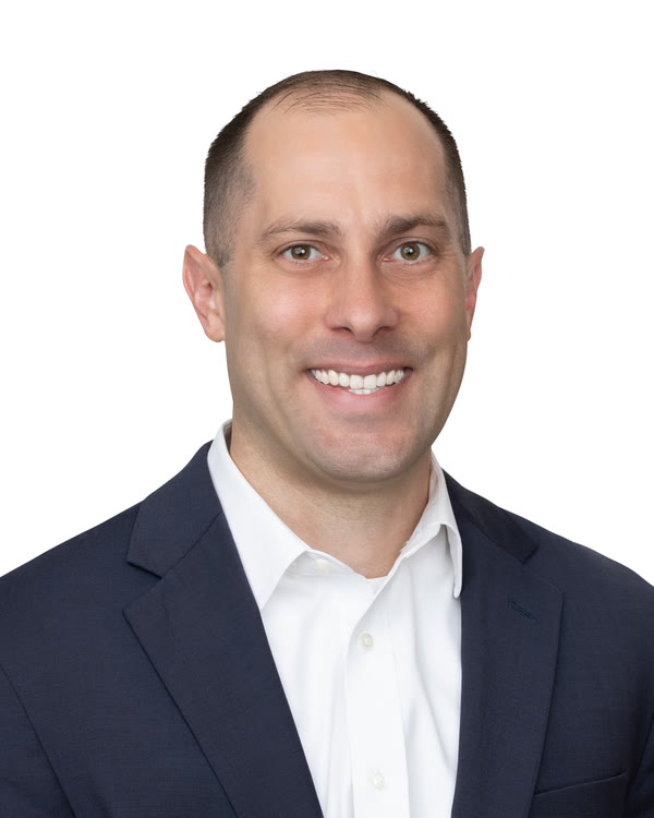 Jon Peck, founder of RANGE Hospitality Advisory, smiling, in a navy blazer and open-collared white shirt